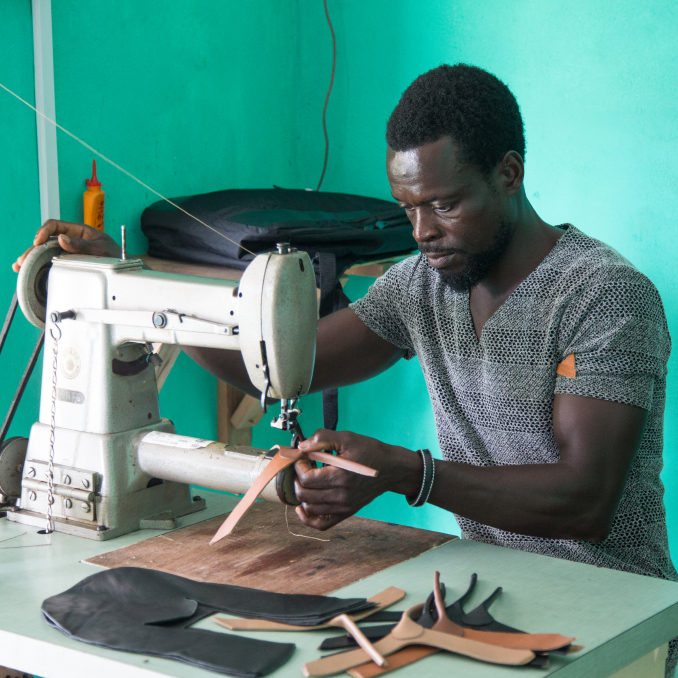 Man stitching leather on sewing machine